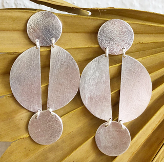 Pair of silver earrings on a textured surface